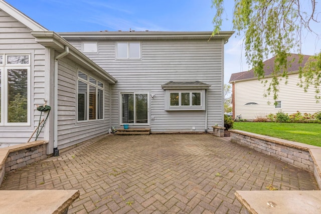 rear view of property featuring a patio area and a lawn