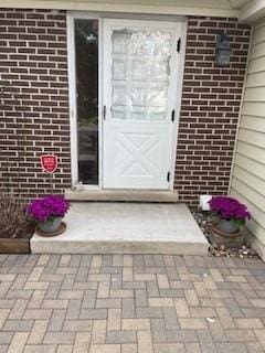view of exterior entry with brick siding