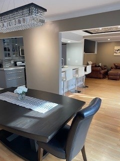 dining area featuring crown molding and light wood finished floors