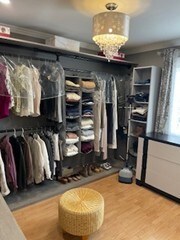 walk in closet with wood finished floors