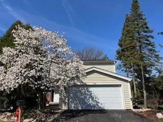 view of side of property featuring driveway and a garage