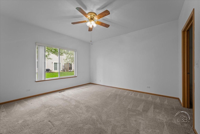 carpeted spare room featuring a ceiling fan and baseboards