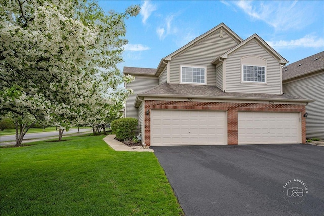 traditional home featuring driveway, brick siding, a garage, and a front yard