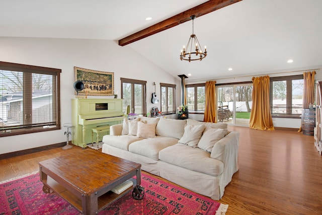 living room featuring lofted ceiling with beams, a chandelier, light wood-type flooring, baseboards, and recessed lighting