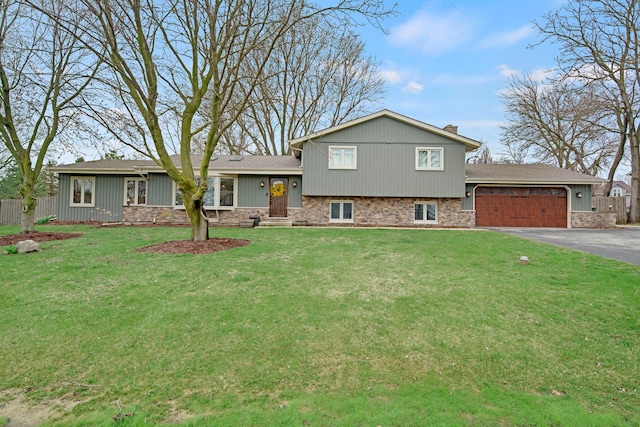 tri-level home with fence, a front lawn, driveway, and a garage