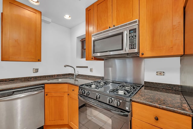 5014 N Oakley Ave Unit G, Chicago, IL 60625 - kitchen featuring stainless steel appliances, tile patterned flooring, a sink, and dark stone counters