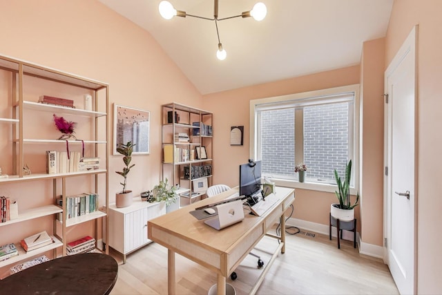 home office featuring light wood-style floors and vaulted ceiling