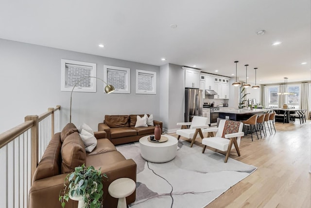 living room with light wood-style flooring and recessed lighting