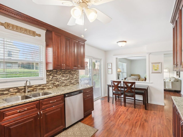 kitchen with stainless steel dishwasher, a sink, reddish brown cabinets, ceiling fan, and backsplash