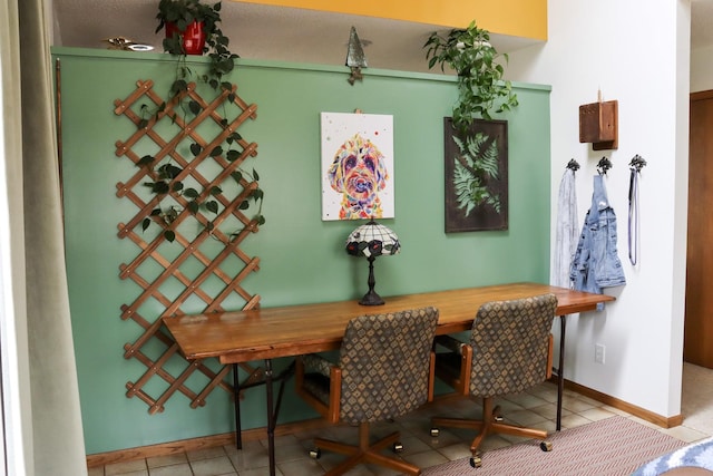 dining room featuring baseboards and tile patterned flooring