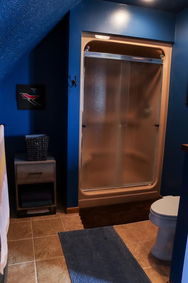 full bathroom featuring toilet, an enclosed shower, and tile patterned floors