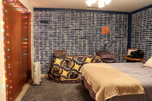 carpeted bedroom featuring brick wall