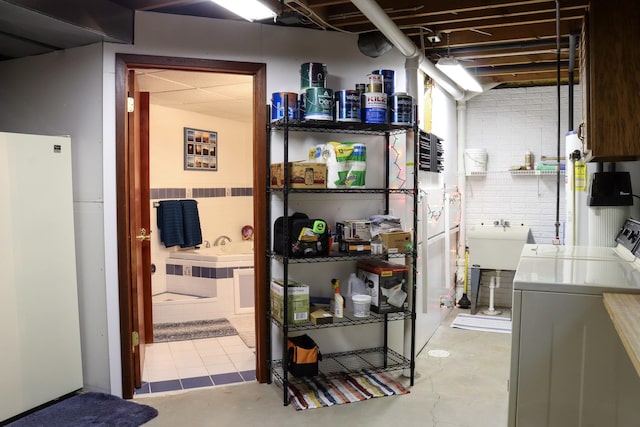 below grade area featuring freestanding refrigerator and washer and dryer