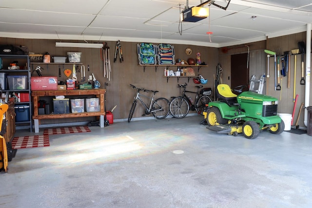 garage with wood walls and a garage door opener