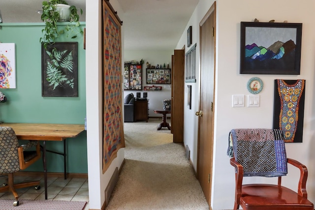 hallway with carpet floors, baseboards, and a barn door