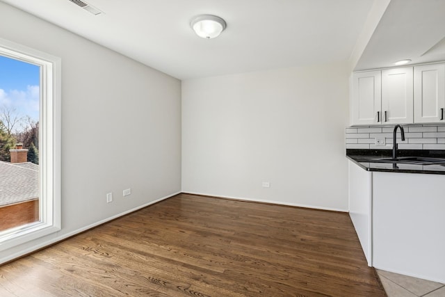 1927 Tanglewood Dr Unit 4A, Glenview, IL 60025 - unfurnished dining area featuring a sink, visible vents, baseboards, and wood finished floors