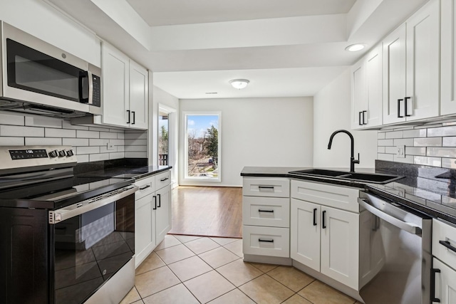 1927 Tanglewood Dr Unit 4A, Glenview, IL 60025 - kitchen with appliances with stainless steel finishes, a sink, white cabinets, and dark countertops