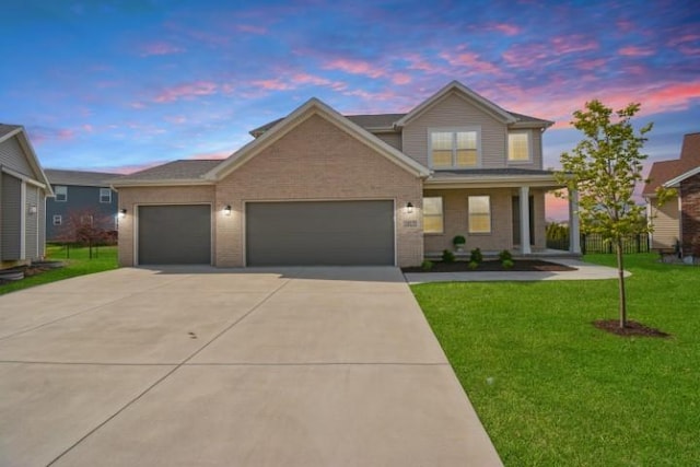 traditional home with concrete driveway, brick siding, a front yard, and a garage