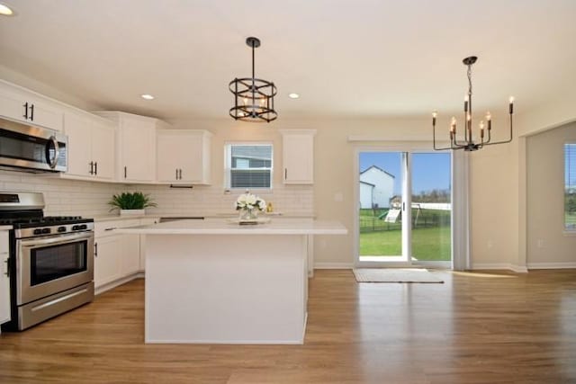 kitchen featuring recessed lighting, decorative backsplash, stainless steel appliances, and an inviting chandelier