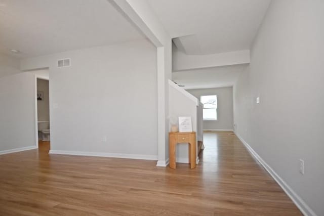 interior space featuring baseboards, visible vents, and light wood finished floors