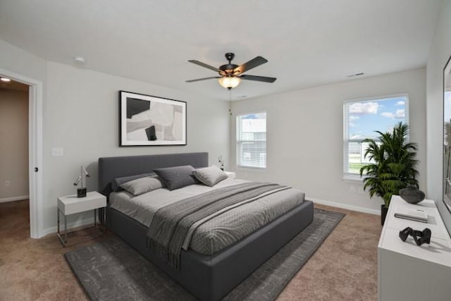 bedroom with ceiling fan, baseboards, and light carpet