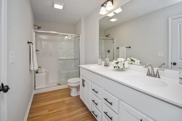 bathroom featuring a sink, a shower stall, and toilet