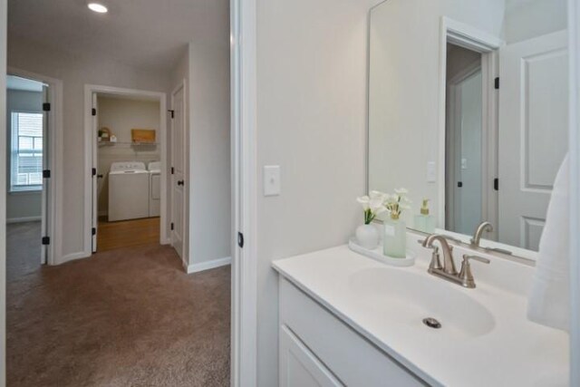 bathroom featuring independent washer and dryer, vanity, and baseboards
