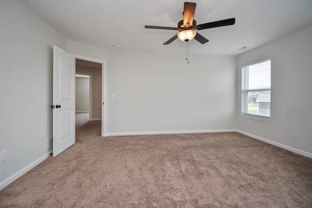 unfurnished room with carpet floors, a ceiling fan, and baseboards