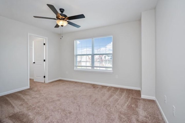 empty room with a ceiling fan, baseboards, and carpet floors