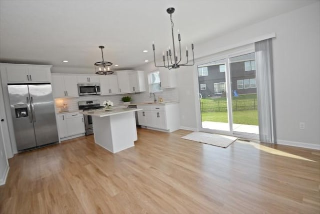 kitchen featuring a notable chandelier, decorative backsplash, baseboards, and stainless steel appliances