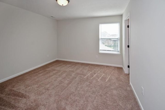 carpeted empty room with baseboards