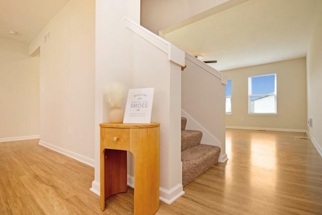 stairs with wood finished floors and baseboards