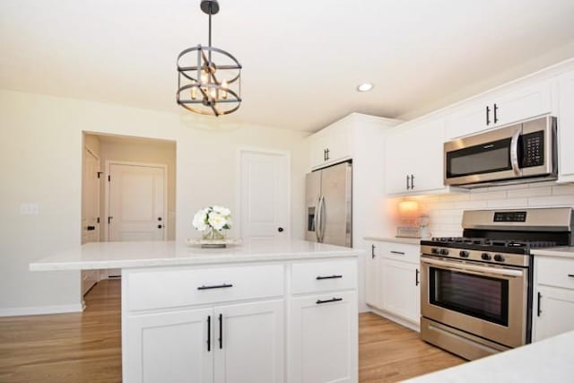 kitchen featuring baseboards, appliances with stainless steel finishes, tasteful backsplash, and light countertops