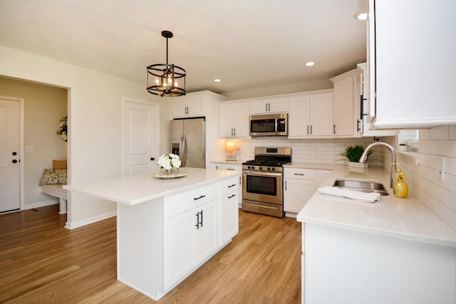 kitchen with light wood-style flooring, appliances with stainless steel finishes, decorative backsplash, and a sink