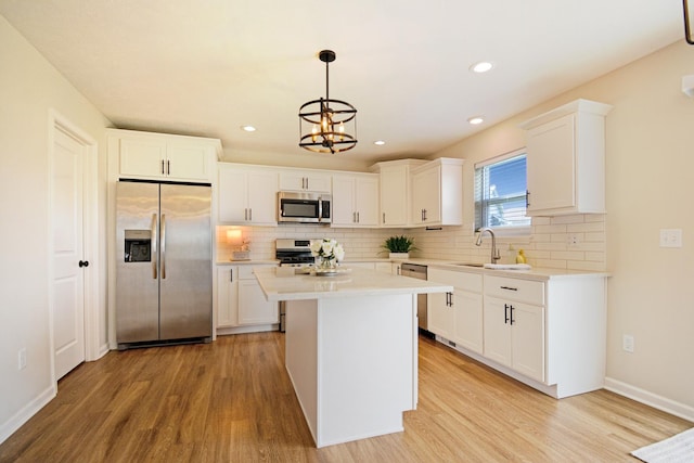 kitchen featuring decorative backsplash, light wood-style flooring, a sink, and appliances with stainless steel finishes