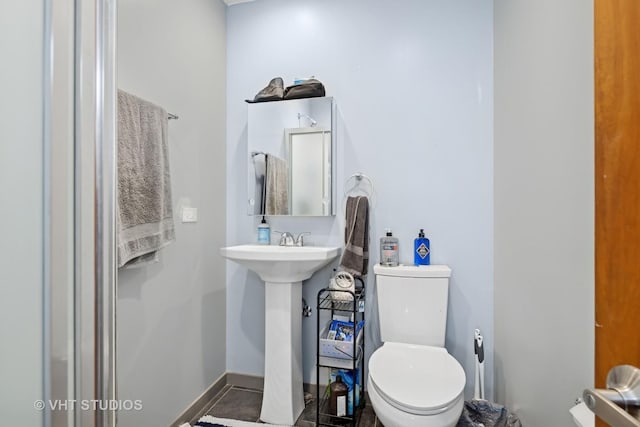 bathroom featuring a sink, baseboards, and toilet