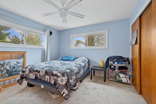 bedroom with carpet flooring, ceiling fan, and multiple windows