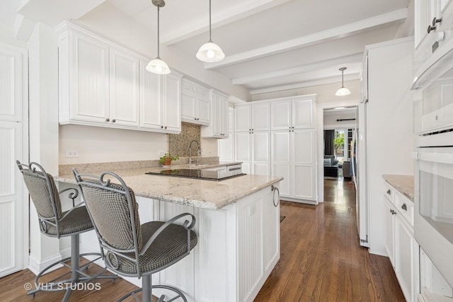 209 W Lake St, Barrington, IL 60010 - kitchen featuring white cabinets, a peninsula, dark wood-style floors, beamed ceiling, and a kitchen breakfast bar