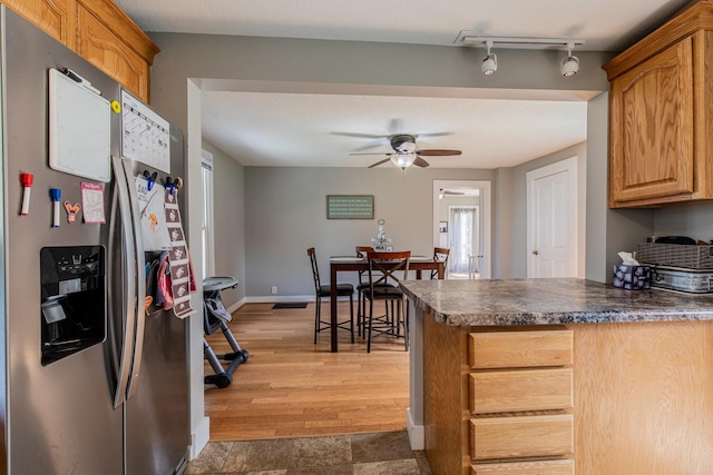 112 E Peru St, Princeton, IL 61356 - kitchen featuring stainless steel fridge, a peninsula, ceiling fan, dark countertops, and light wood-style floors