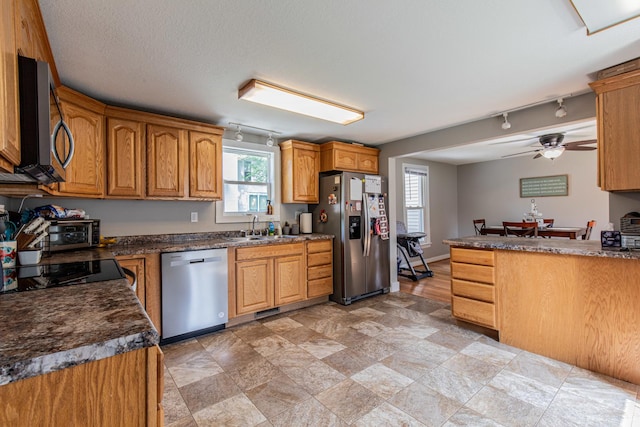112 E Peru St, Princeton, IL 61356 - kitchen with appliances with stainless steel finishes, track lighting, a ceiling fan, dark countertops, and brown cabinetry