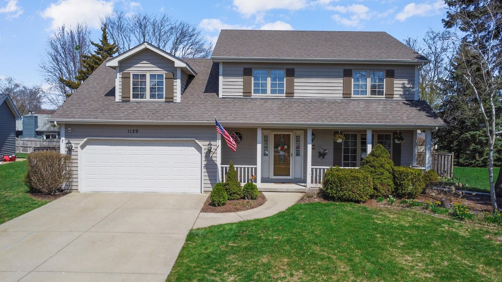 1129 Thelin Ct, Batavia, IL 60510 - traditional-style home with a garage, covered porch, a front lawn, a shingled roof, and driveway