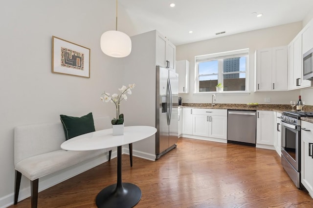 625 W Patterson Ave Unit 3E, Chicago, IL 60613 - kitchen featuring appliances with stainless steel finishes, light wood-style flooring, a sink, white cabinetry, and dark stone countertops