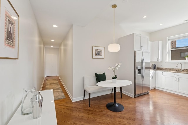 625 W Patterson Ave Unit 3E, Chicago, IL 60613 - kitchen with stainless steel fridge with ice dispenser, light wood-style flooring, a sink, white cabinetry, and baseboards