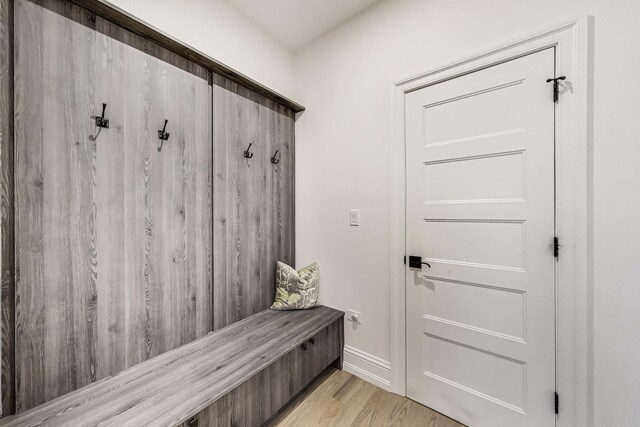 mudroom featuring light wood finished floors and baseboards