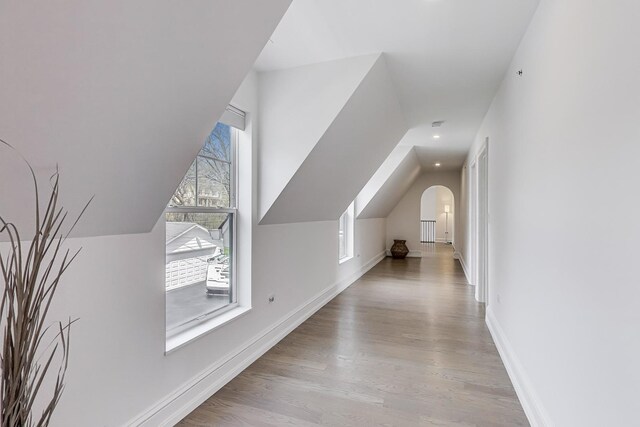 bonus room featuring vaulted ceiling, wood finished floors, and baseboards