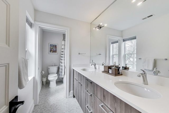 full bath featuring visible vents, toilet, baseboards, and a sink