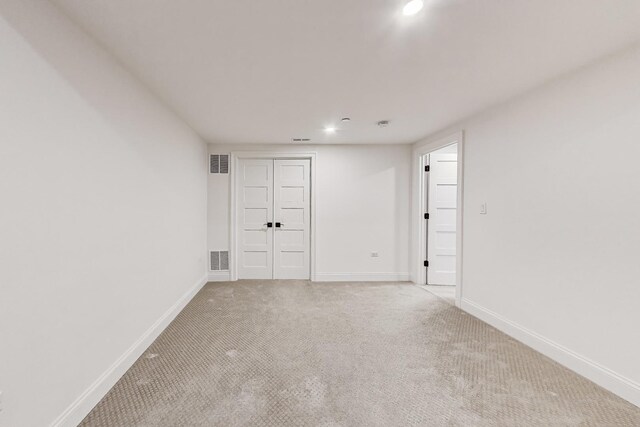 spare room with light carpet, baseboards, and recessed lighting