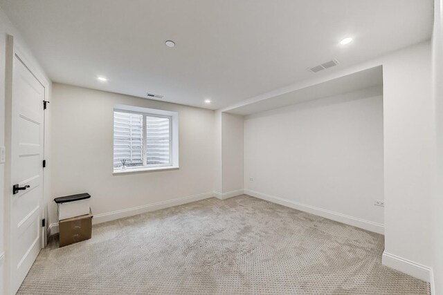 carpeted spare room featuring baseboards, visible vents, and recessed lighting