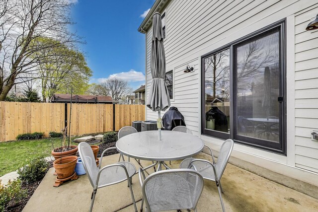 view of patio / terrace with outdoor dining area, fence, and cooling unit
