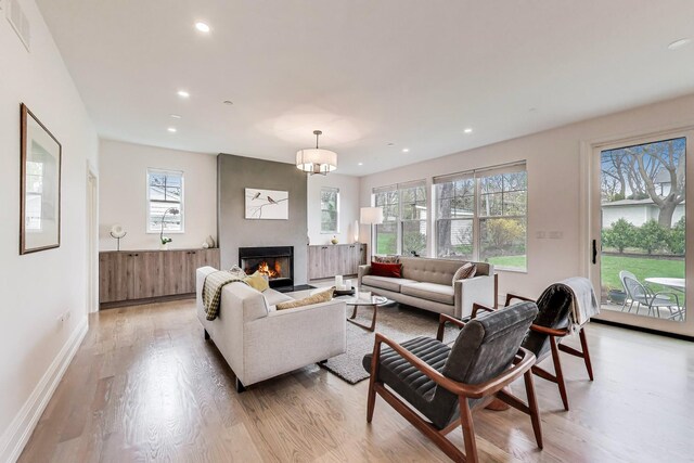 living room with plenty of natural light, visible vents, and light wood-type flooring